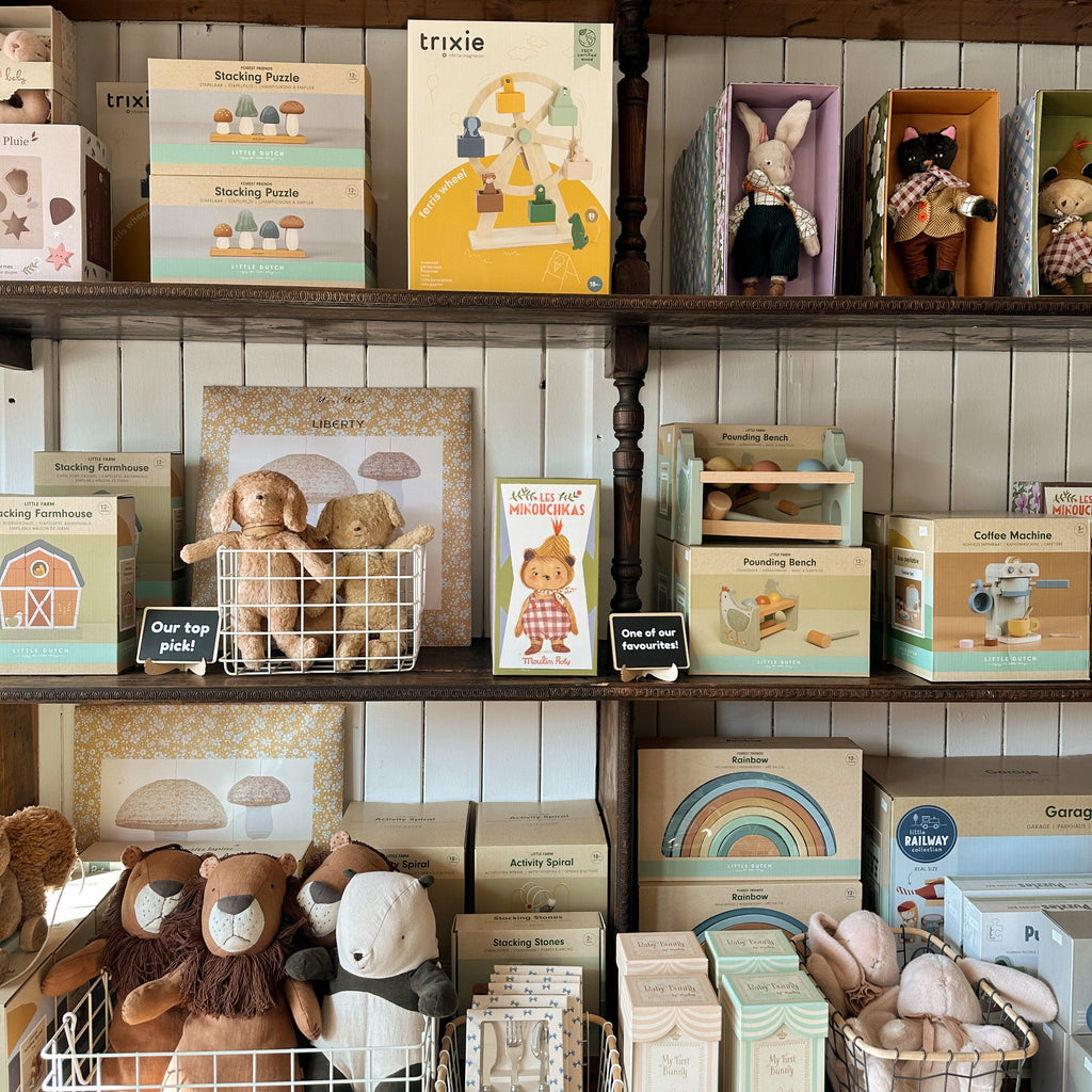 Wooden shelves with toys, books, and decorative items against a tiled wall.
