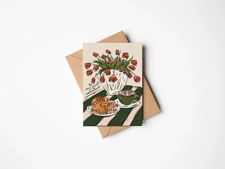Jenna Crush Valentine's greetings card with coffee, croissant, and tulips on a green tablecloth.
