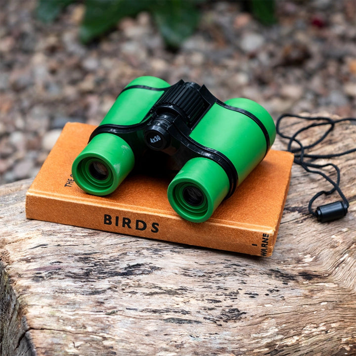 Green Rex Nature Trail binoculars on a book outdoors
